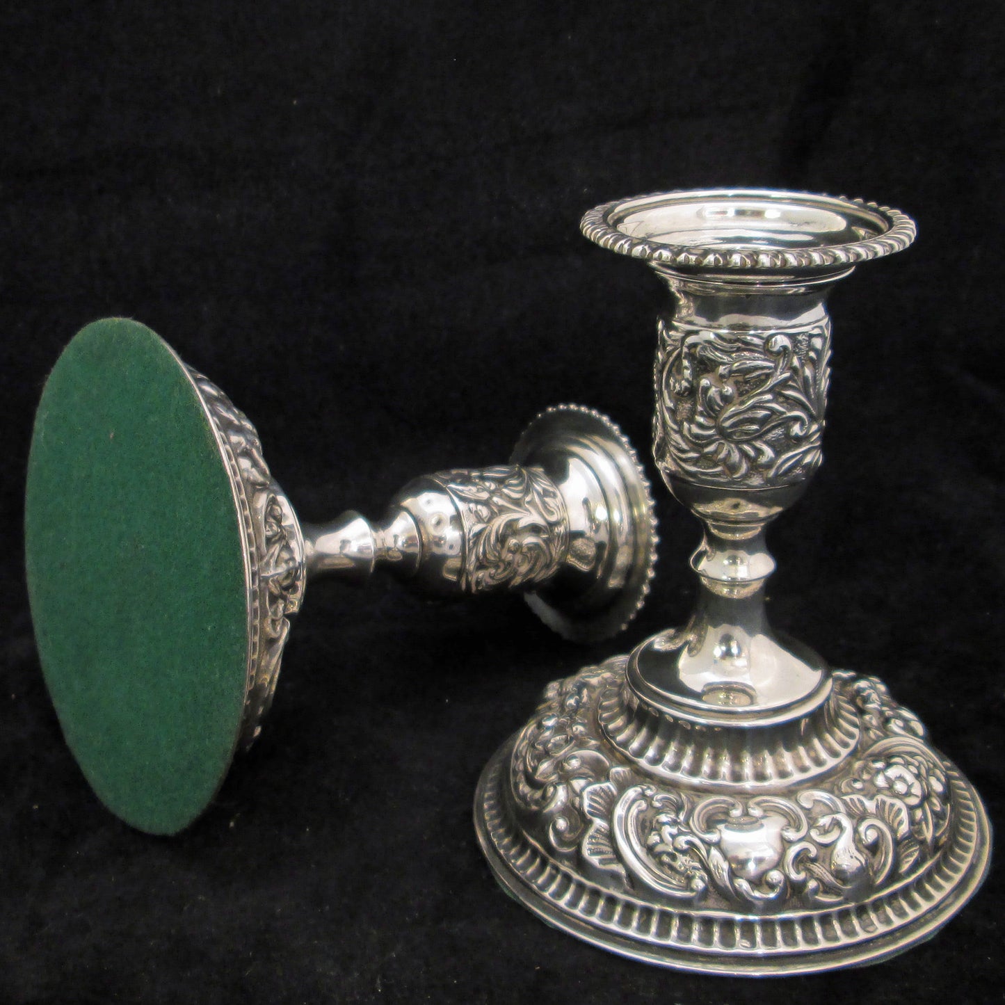 A pair of sterling silver embossed candlesticks.