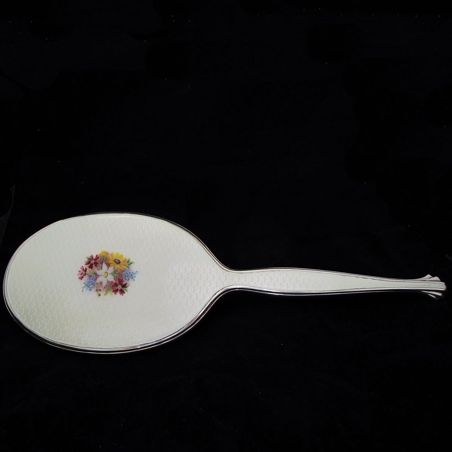 A sterling silver and enamel hand mirror.