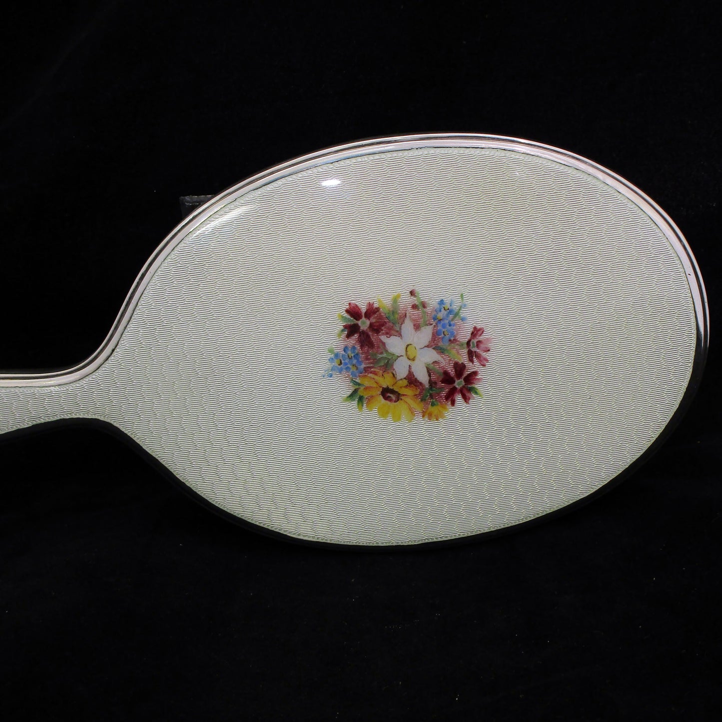 A sterling silver and enamel hand mirror.