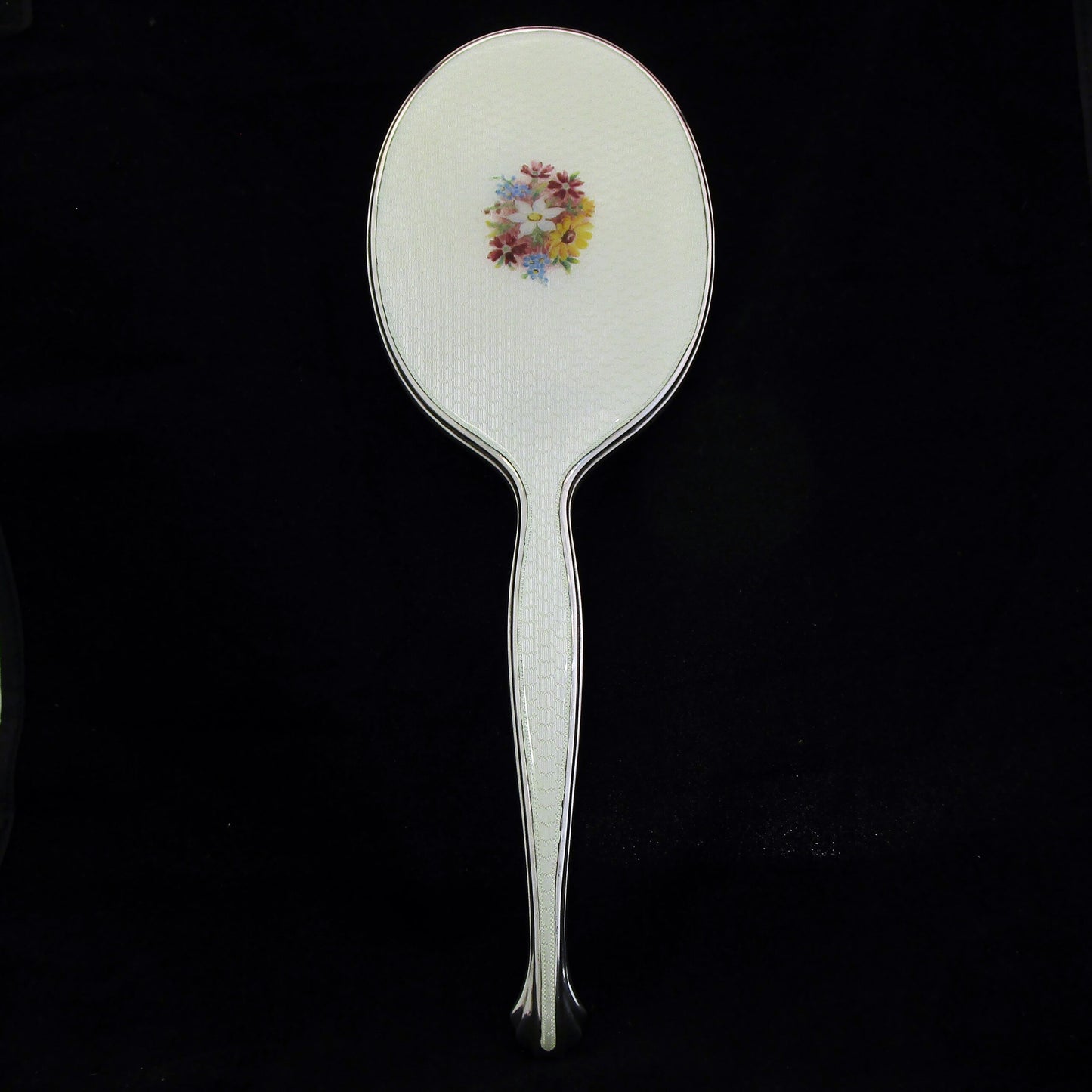 A sterling silver and enamel hand mirror.