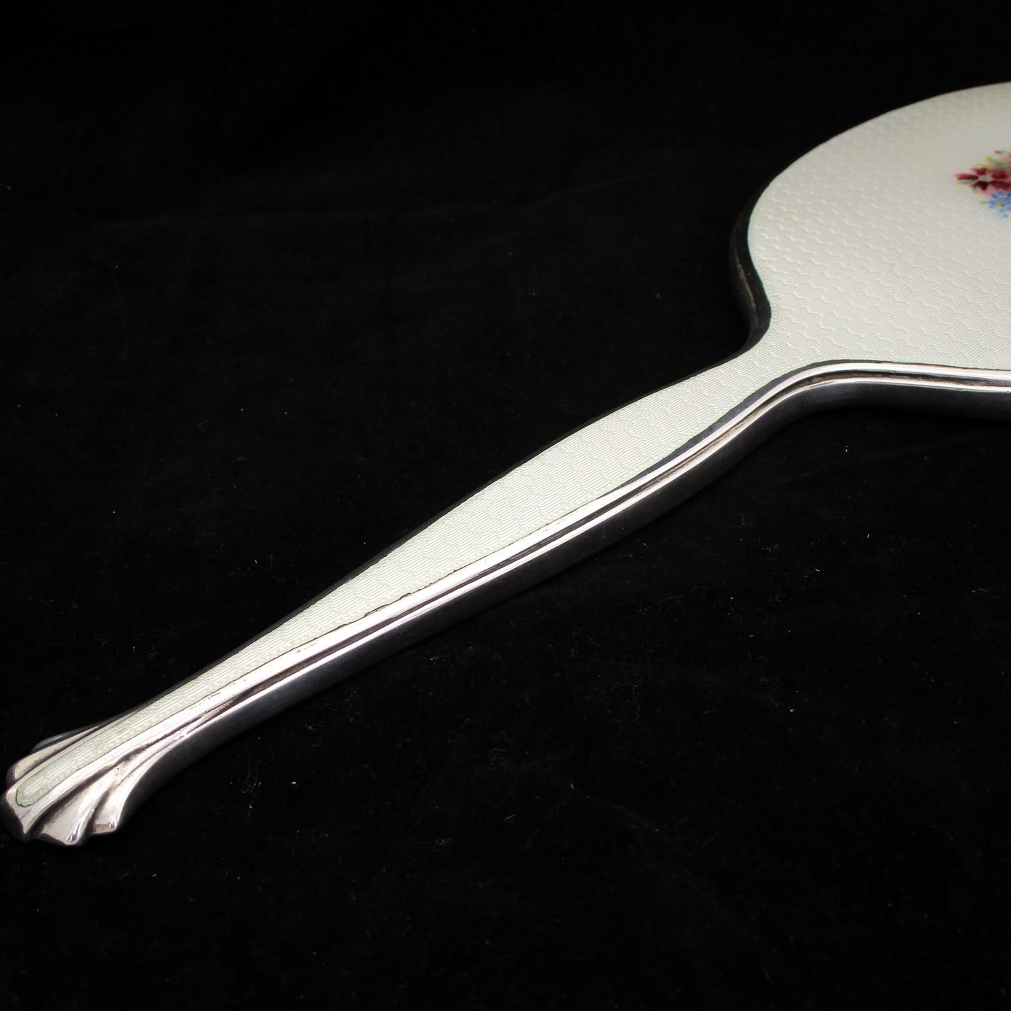 A sterling silver and enamel hand mirror.