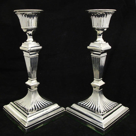 A pair of sterling silver Georgian style candle sticks.