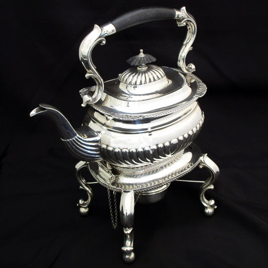 A quality sterling silver kettle on a stand.