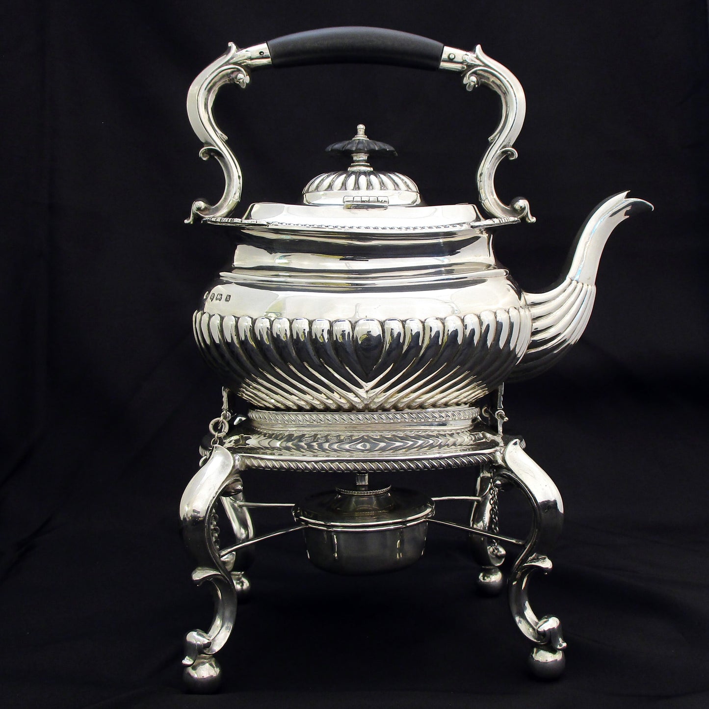 A quality sterling silver kettle on a stand.