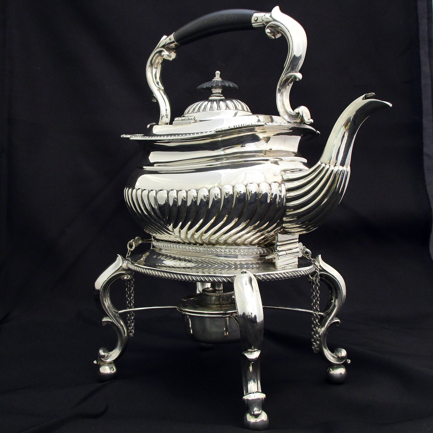 A quality sterling silver kettle on a stand.