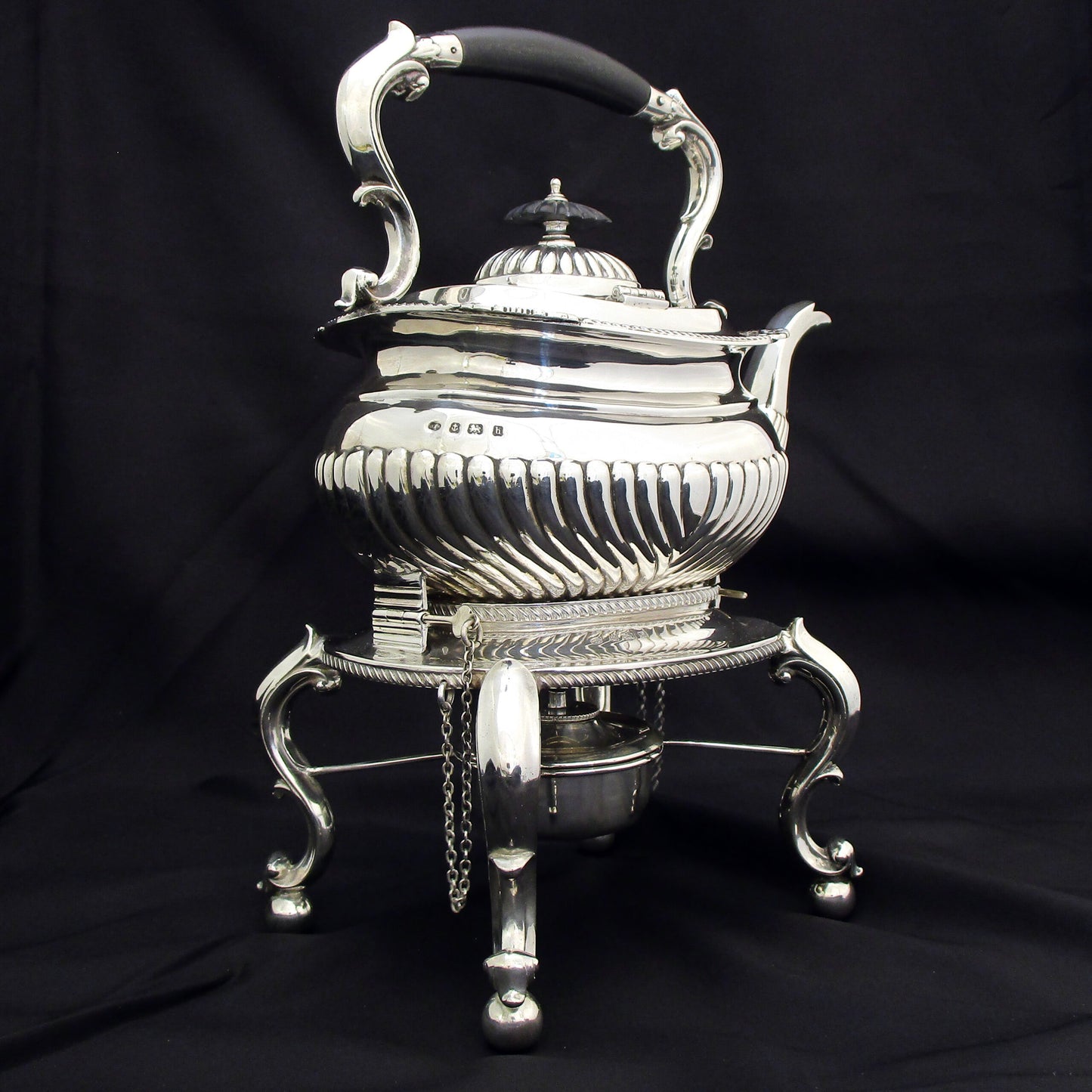 A quality sterling silver kettle on a stand.