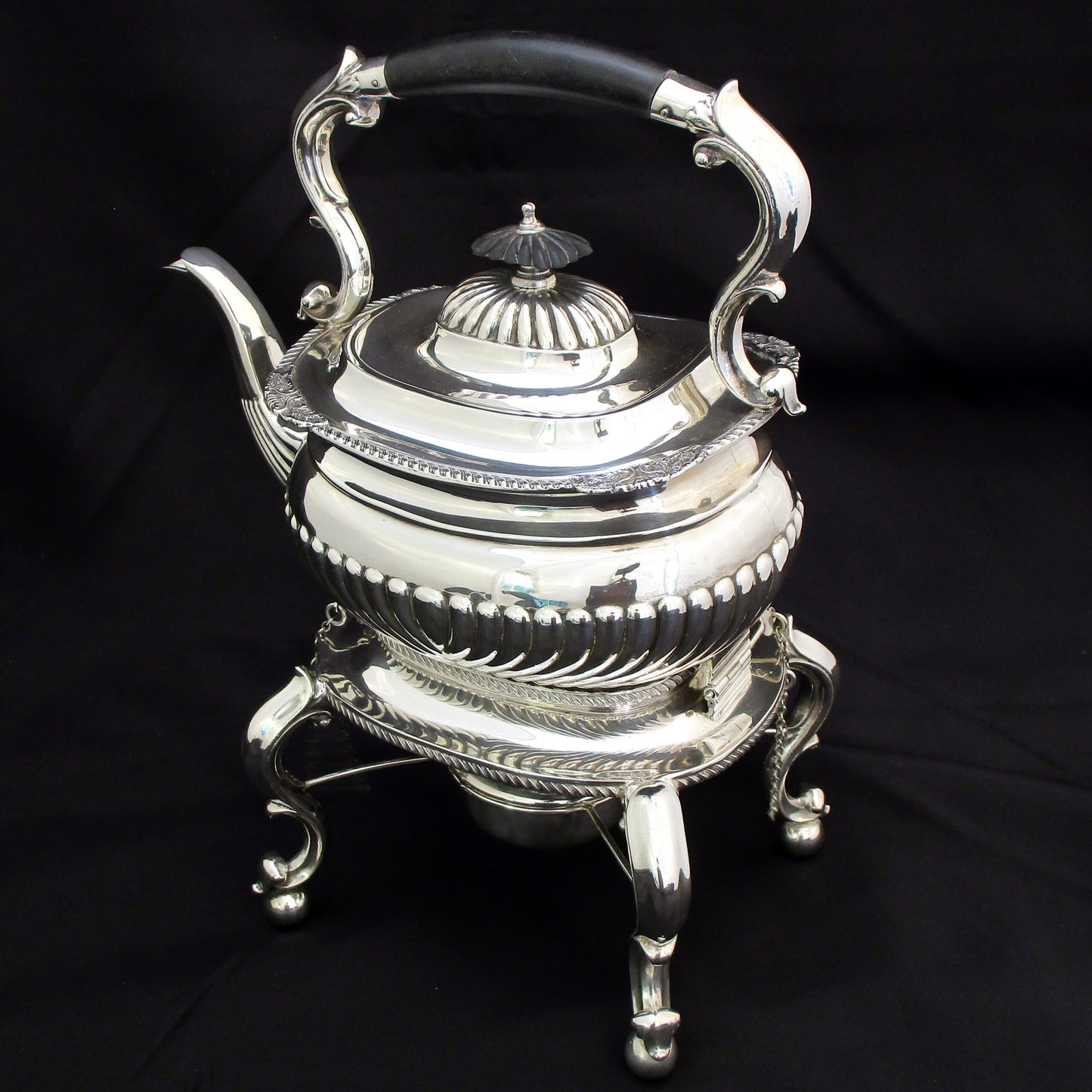 A quality sterling silver kettle on a stand.