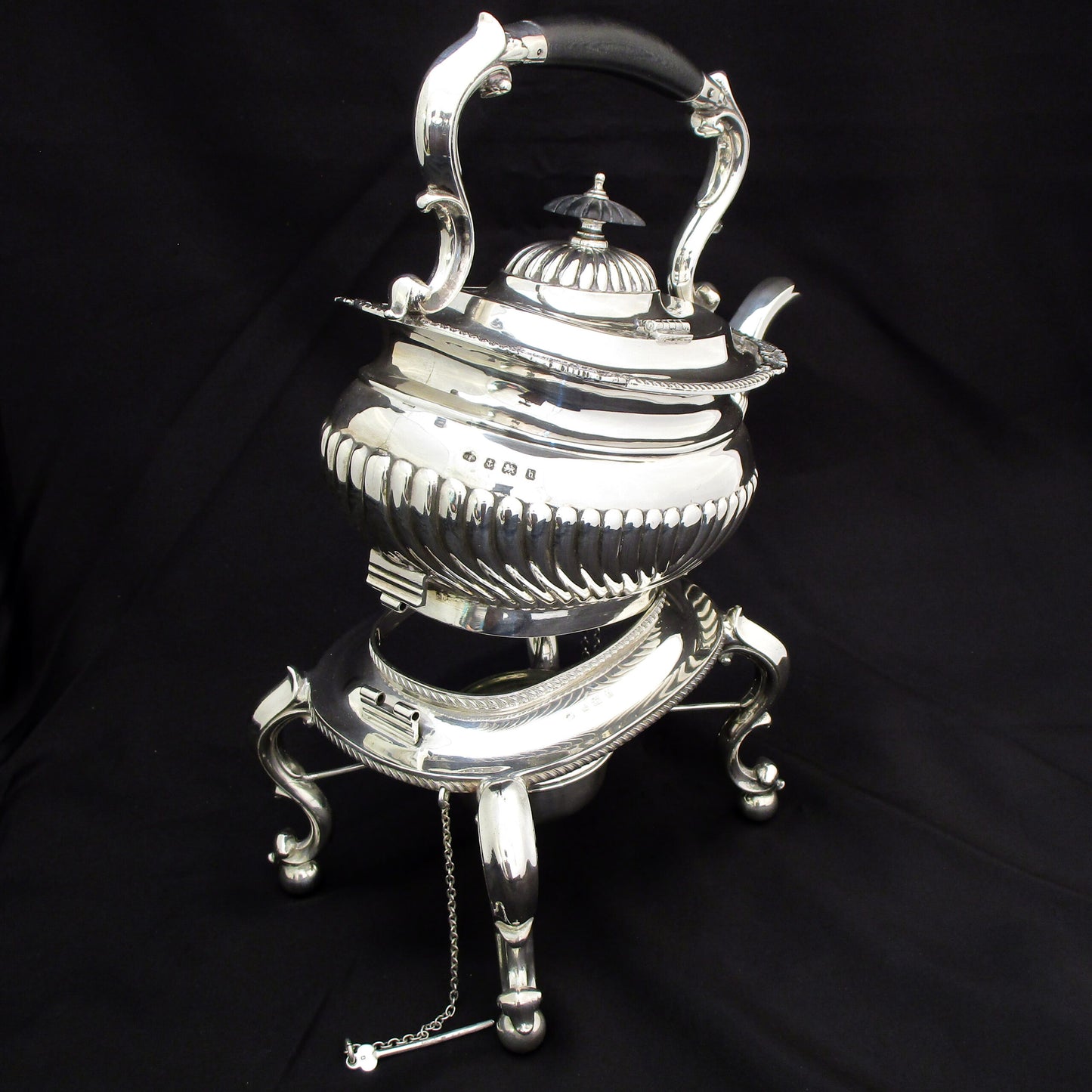 A quality sterling silver kettle on a stand.