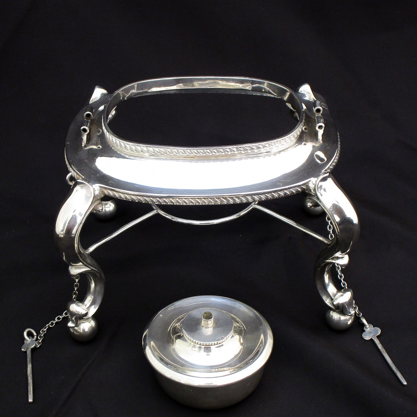 A quality sterling silver kettle on a stand.