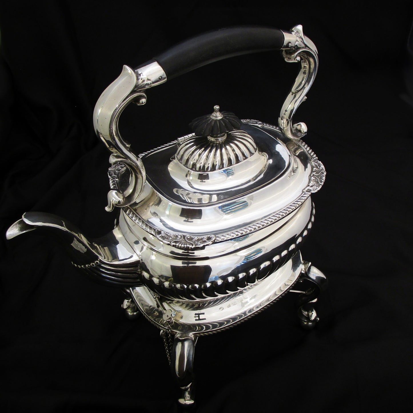 A quality sterling silver kettle on a stand.