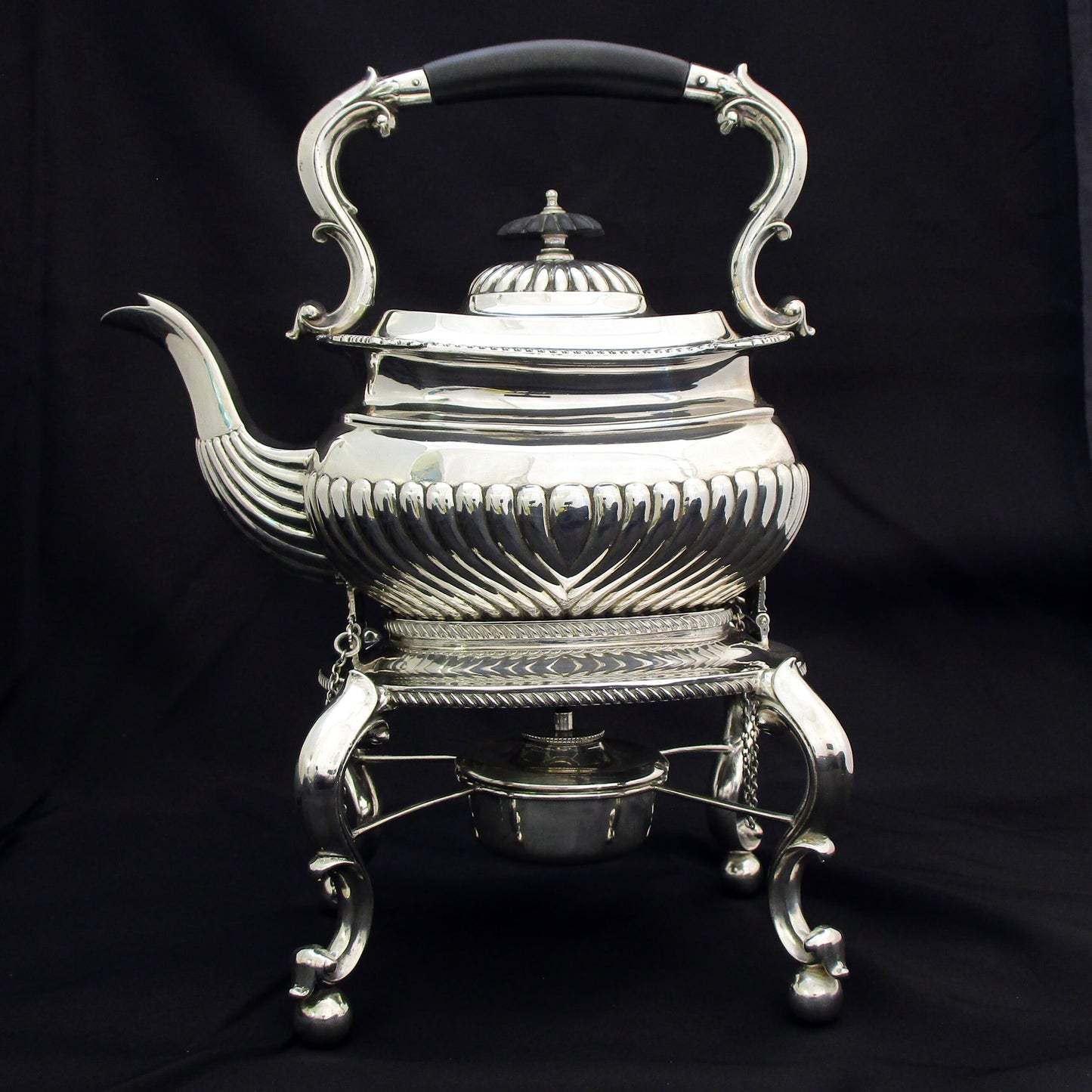 A quality sterling silver kettle on a stand.