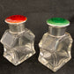 A pair of antique silver and enamel topped perfume bottles