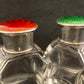 A pair of antique silver and enamel topped perfume bottles