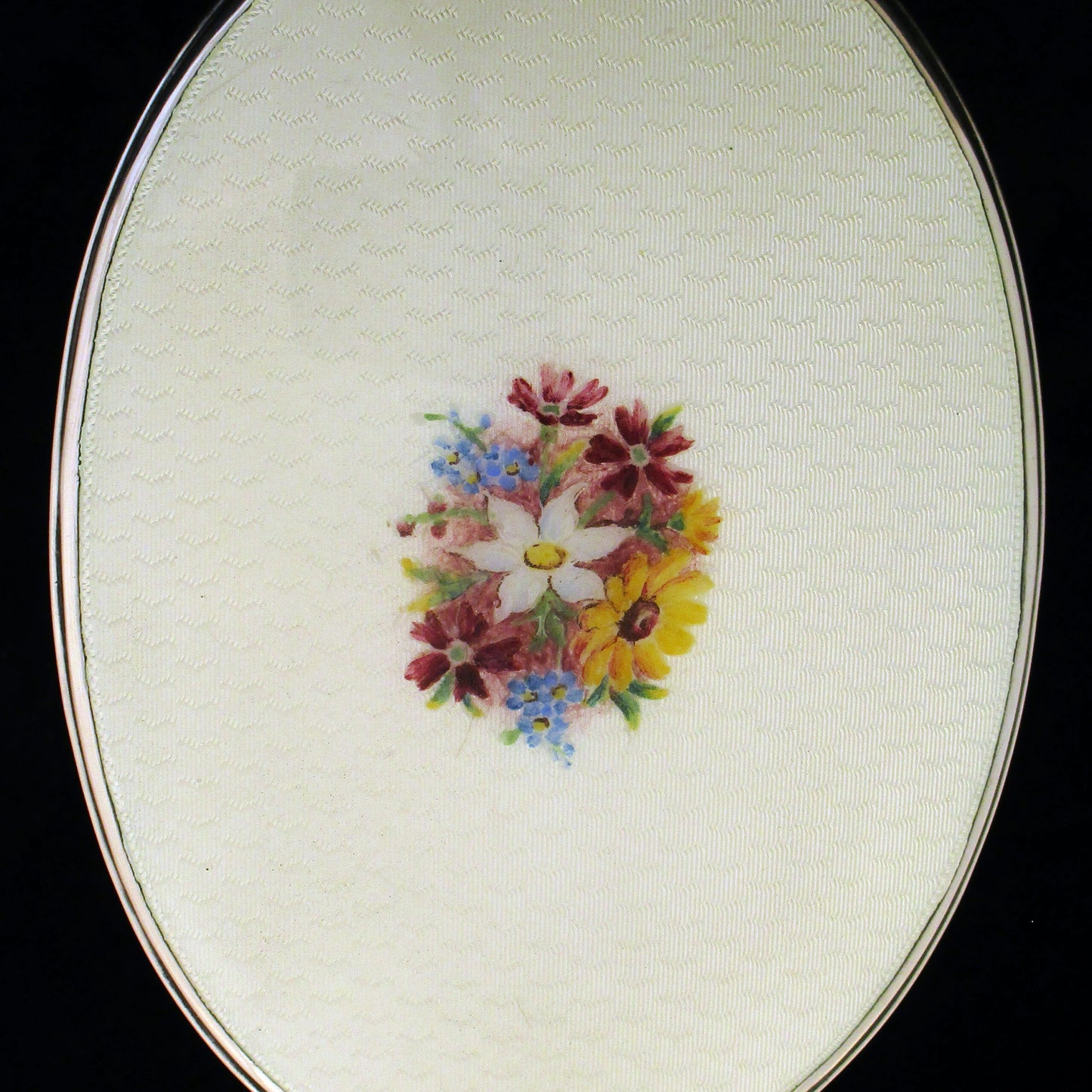 A sterling silver and enamel hand mirror.