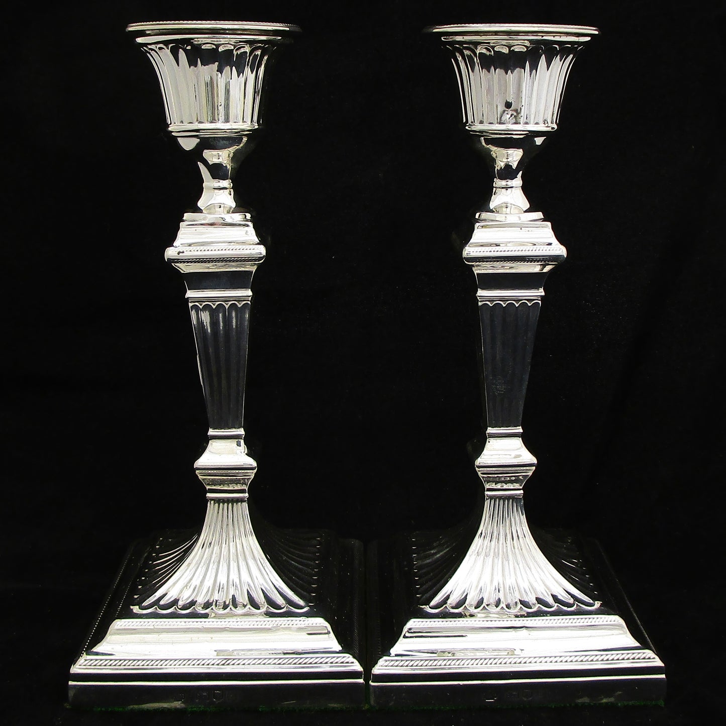 A pair of sterling silver Georgian style candle sticks.