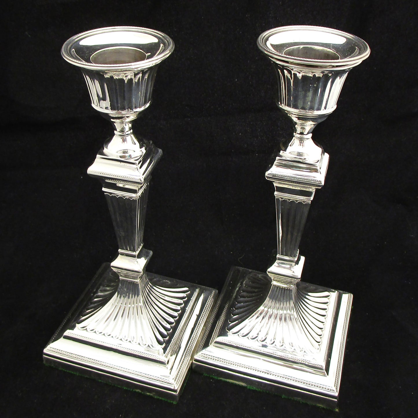 A pair of sterling silver Georgian style candle sticks.