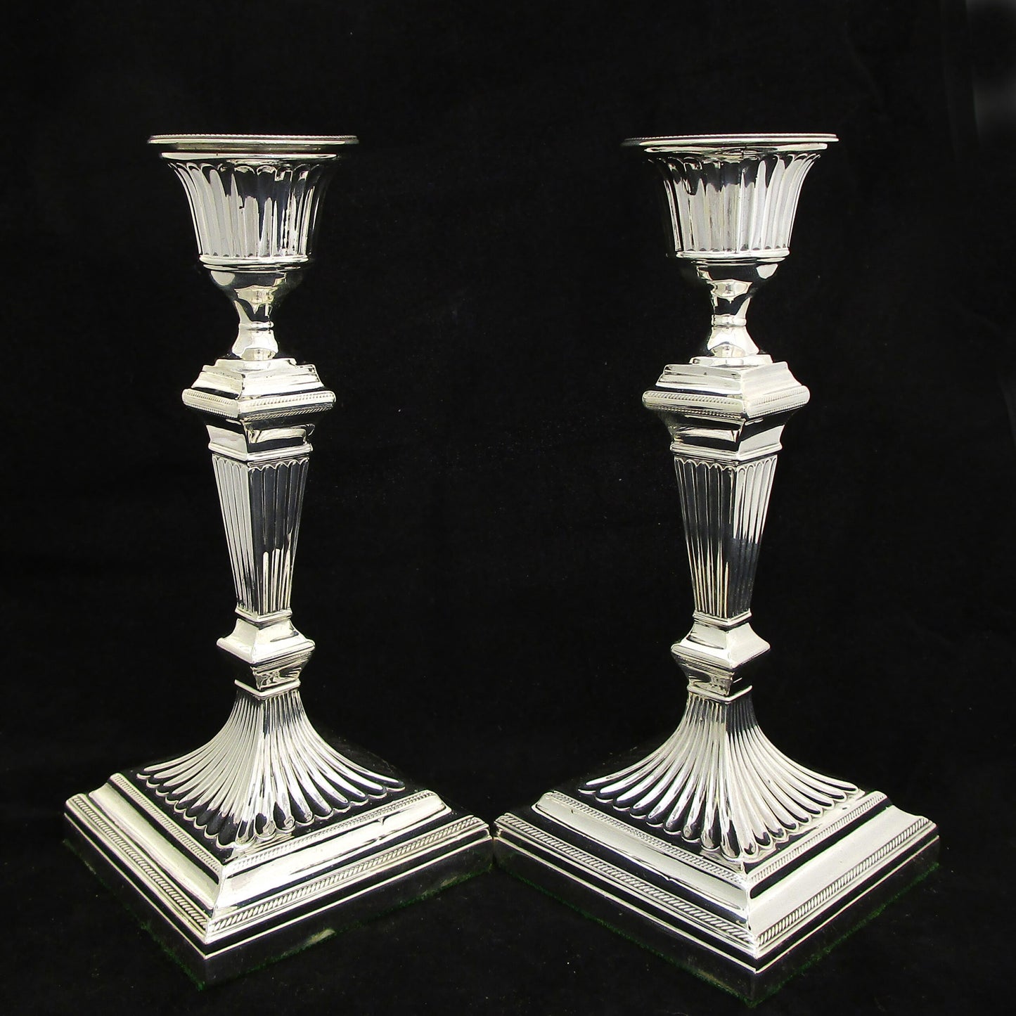 A pair of sterling silver Georgian style candle sticks.