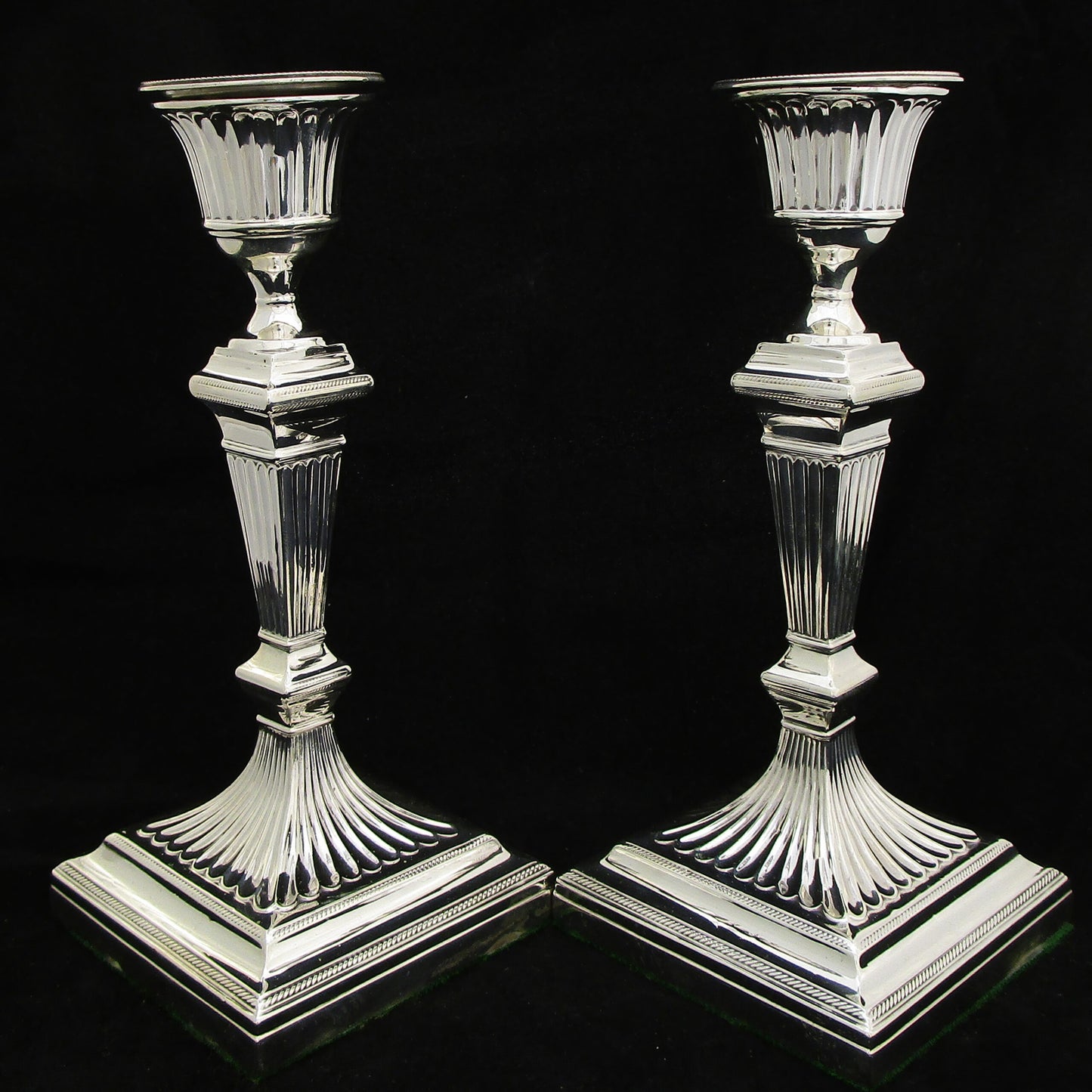 A pair of sterling silver Georgian style candle sticks.