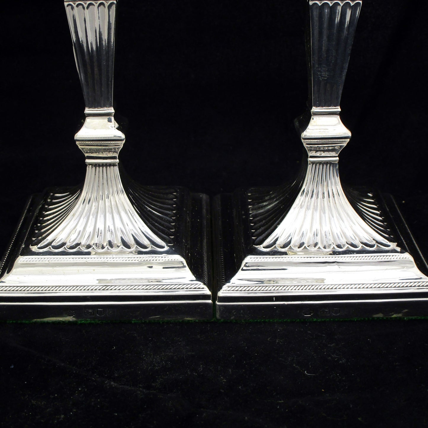 A pair of sterling silver Georgian style candle sticks.