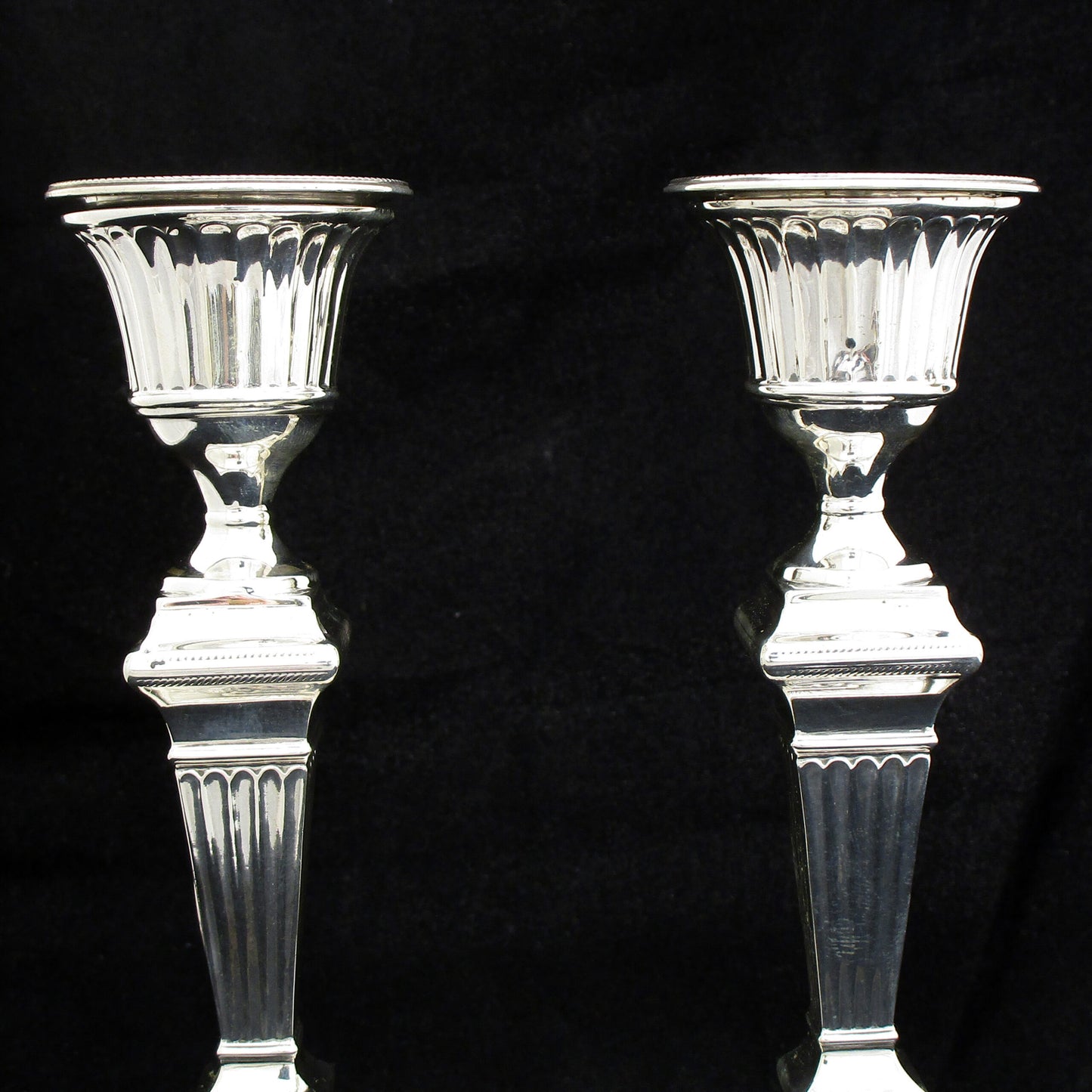 A pair of sterling silver Georgian style candle sticks.