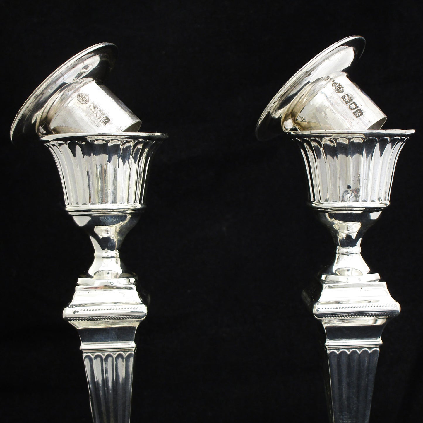 A pair of sterling silver Georgian style candle sticks.