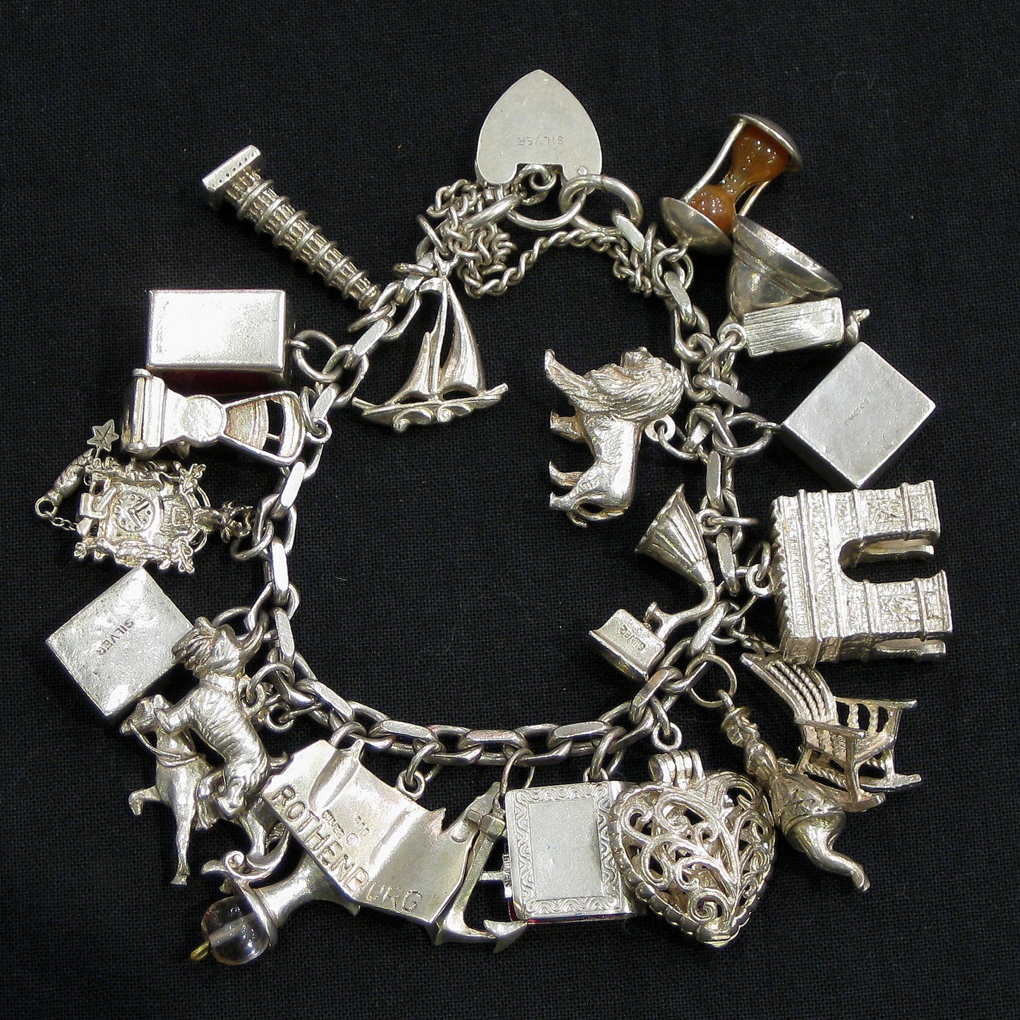Silver charm bracelet with assorted charms.