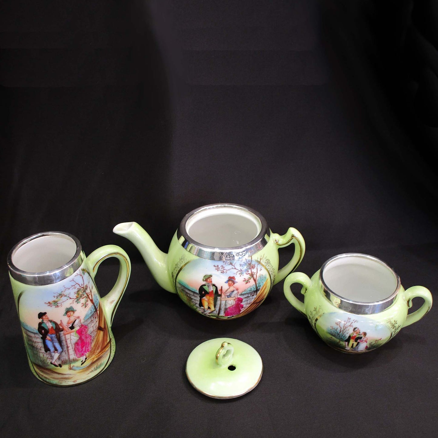 Antique hand painted porcelain tea set with silver rims.